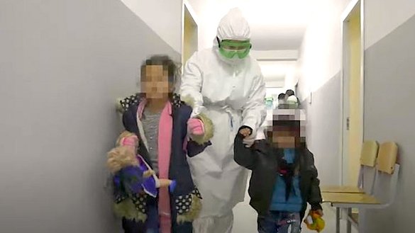 Дети, возвращенные из Сирии в рамках операции «Жусан», в сопровождении казахстанского медработника. Кадр из видео КНБ Казахстана.