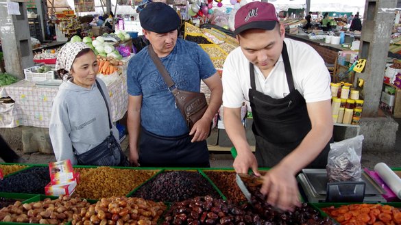 The Murataliyev family of Bishkek makes purchases at the Osh Bazaar on April 27. Demand for dates, a staple of iftar, becomes three to four times higher than usual during the holy month of Ramadan, says Kubanych, a dried-fruit vendor. [Maksat Osmonaliyev/Caravanserai]