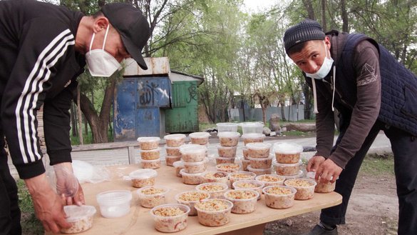 Workers at the Kelechek mosque in Bishkek pack plov and other food into containers on April 27. The food is to be handed out to Muslims who are fasting and to the needy. [Maksat Osmonaliyev/Caravanserai]