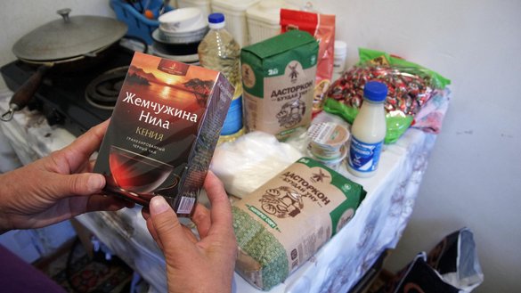 An elderly woman in Bishkek examines her share of donated food during the holy month of Ramadan, on April 29. [Maksat Osmonaliyev/Caravanserai]